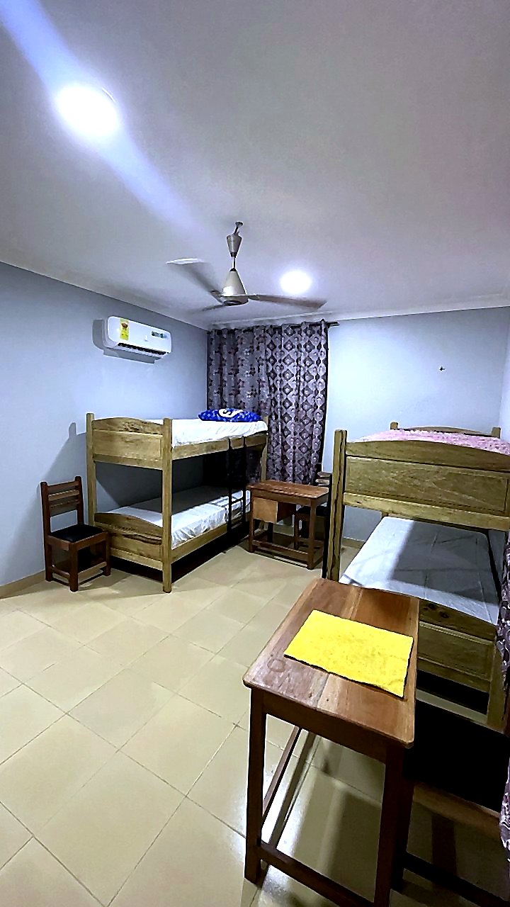 Two-bed room with wardrobe, TV, desk, and air conditioning